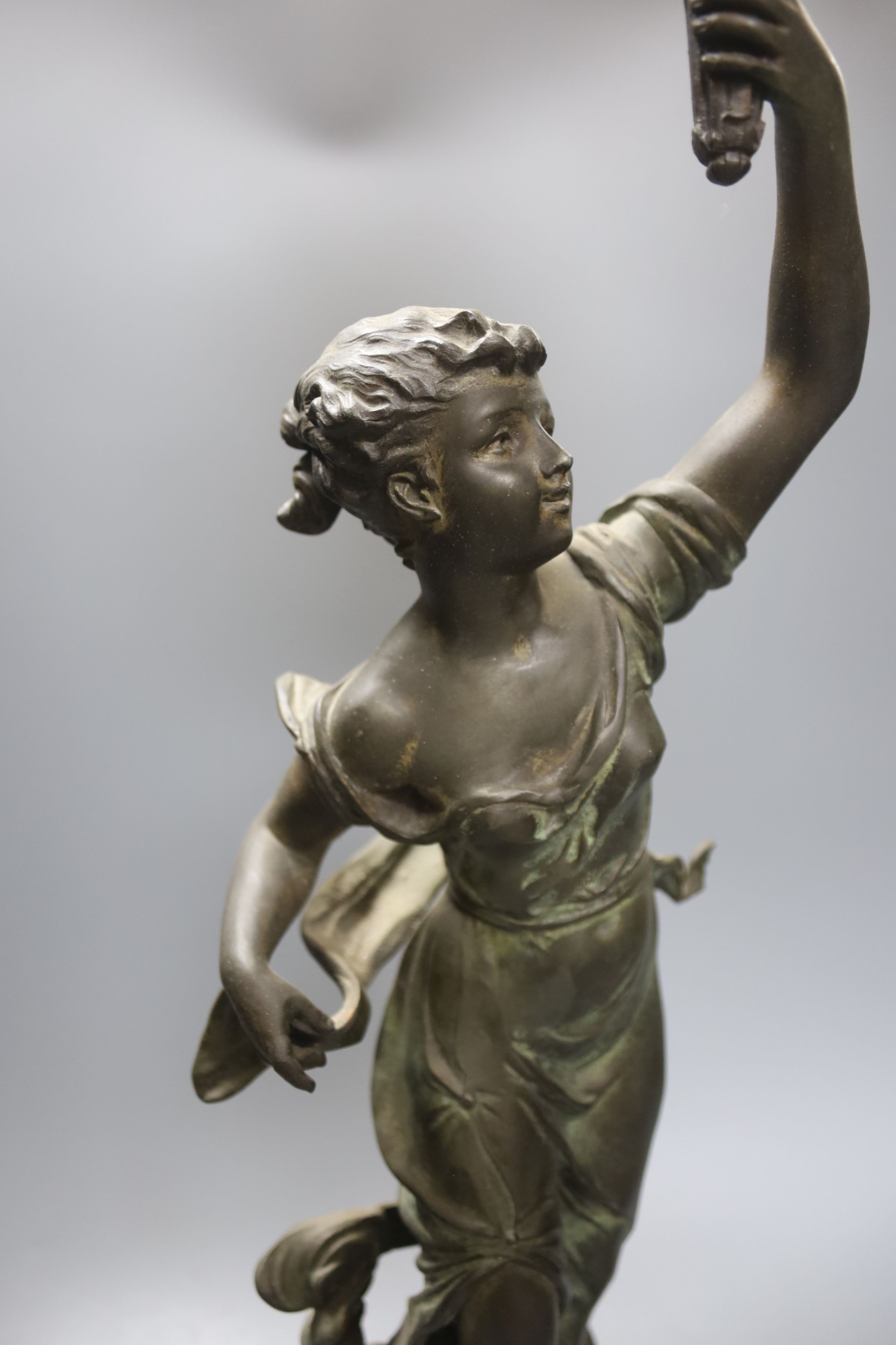 An Art Nouveau spelter figural flame shaded table lamp,74 cms high.
